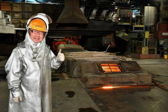 포항제철소 제선부 강원구 과장이 2고로에서 쇳물 출선작업을 하던 중 사진 촬영에 임하고 있다. 고로에서 만들어진 쇳물이 덮개 아래로 흐르고 있다.