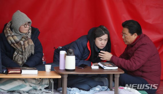 자유한국당 박맹우(오른쪽) 사무총장이 30일 서울 청와대 분수대 앞에서 황교안 대표를 이어 단식을 하고 있는 정미경(왼쪽), 신보라 최고위원을 찾아 단식을 중단할 것을 요구하고 있다.