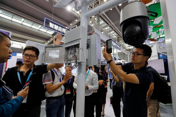 In this Tuesday, Oct. 29, 2019, photo, visitors look at the 5G mobile station and a surveillance camera by China's telecoms equipment giant Huawei on display at the China Public Security Expo in Shenzhen, China's Guangdong province. The U.S. Department of Commerce has proposed requiring case-by-case