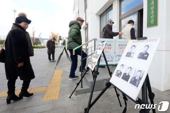 시민들이 3일 오후 광주 동구 옛 전남도청 별관 앞에 전시된 5·18민주화운동 관련 사진들을 보고 있다. 이날 옛 전남도청 별관 1층에서는 '5·18 비공개 사진 대국민 설명회'가 열렸다. 2019.12.3 /뉴스1 © News1 한산 기자