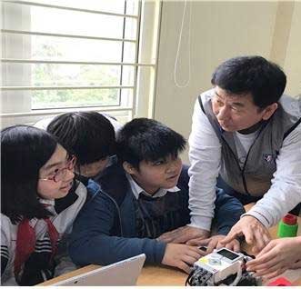 이석행 이사장(오른쪽)이 베트남 하노이 응오시리엔중학교 학생들과 로봇 프로그래밍 실습을 하고 있다.