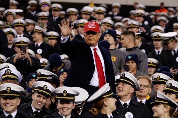 도널드 트럼프 미국 대통령이 14일(현지시간)미국 육군사관학교와 해군사관학교의 축구 경기가 열리고 있는 필라델피아의 경기장에 방문해 손을 흔들고 있다. AP뉴시스