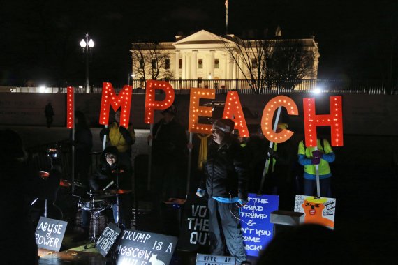 Protesters hold signs in front of the White House Tuesday, Dec. 17, 2019 in Washington. (AP Photo/Steve Helber)