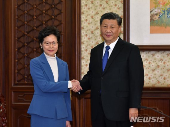 [베이징=AP/뉴시스] 홍콩 공보청이 배포한 사진으로 지난 16일 베이징을 방문한 캐리 람 홍콩 행정장관(왼쪽)이 시진핑 주석을 만나 악수하며 포즈를 취하고 있다. 시 주석은 지난달 방문 때에 이어 이날 다시 람 장관에 대한 지지를 표명했다. 2019. 12. 16.