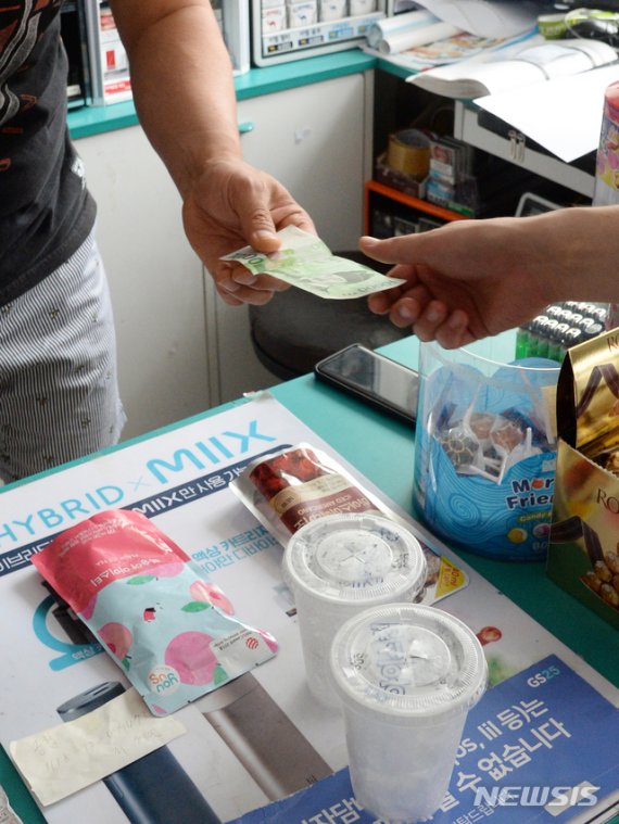 [전주=뉴시스] 김얼 기자 = 편의점에서 음료를 구매하기 위해 온 손님이 현금으로 결제를 하고 있다. 2019.07.24. pmkeul@newsis.com 이 사진은 기사와 직접적인 관련 없음.