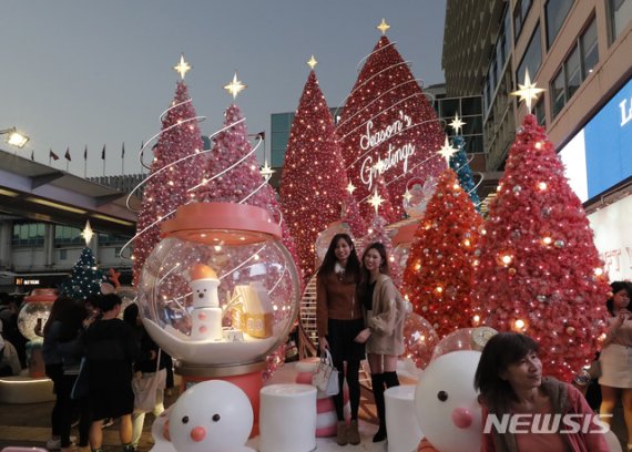 [홍콩=AP/뉴시스] 24일 홍콩의 하버 시티 쇼핑몰에서 고객들이 크리스마스 트리 장식에서 사진 찍기 위해 포즈를 취하고 있다. 2019. 12. 24. 이 사진은 기사와 직접적인 관련 없음.