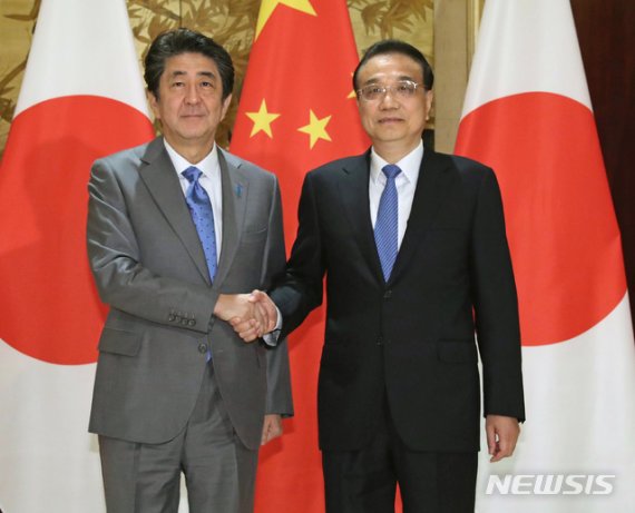 [청두=AP/뉴시스]리커창 중국 국무원 총리(오른쪽)와 아베 신조 일본 총리가 지난 25일 중국 청두시에서 회담을 앞두고 악수하고 있다. 2019.12.26.