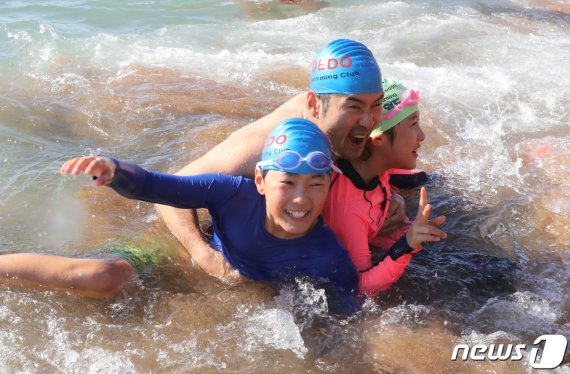 2020년 경자년(庚子年) 새해 첫 날인 1일 제주 서귀포시 중문색달해수욕장에서 제20회 서귀포 겨울바다 국제펭귄수영대회 에 참가한 가족이 물속에서 활짝 웃고 있다. 2020.1.1/뉴스1 © News1 오현지 기자