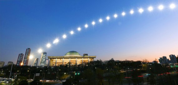 국회의사당을 지나는 태양을 일출부터 20분 간격으로 촬영해서 야경과 레이어 합성을 한 사진.