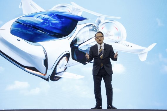 With a shared mobility concept vehicle, Toyota CEO Akio Toyoda talks about building the prototype Toyota city of the future, called the Woven City that will be a fully connected ecosystem powered by hydrogen fuel cells, before the CES tech show Monday, Jan. 6, 2020, in Las Vegas. (AP Photo/Ross D. F