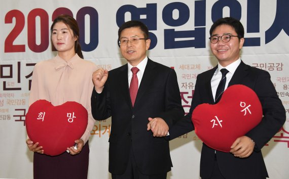 황교안 자유한국당 대표(가운데)가 8일 국회에서 열린 자유한국당 2020 영입인사 환영식에서 '체육계 미투 1호'로 꼽히는 김은희 테니스 코치(왼쪽)와 탈북민 출신 인권운동가 지성호씨에게 '희망', '자유'라고 새겨진 하트모양의 쿠션을 전달한 후 기념촬영을 하고 있다. 사진=김범석 기자