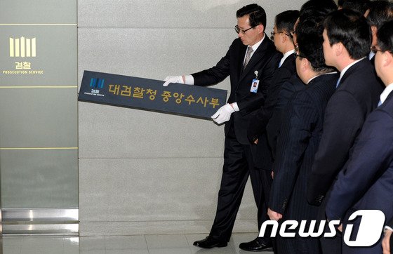 2013년 4월23일 오후 서울 서초동 대검찰청에서 열린 중수부 현판 강하식에서 대검 관리과장이 현판을 떼어내고 있다. (뉴스1 DB)