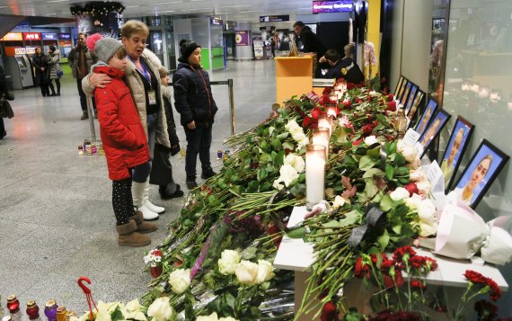 People look at a memorial at Borispil international airport outside in Kyiv, Ukraine, Thursday, Jan. 9, 2020, for the flight crew members of the Ukrainian 737-800 plane that crashed on the outskirts of Tehran. The crew of a Ukrainian jetliner that crashed in Iran, killing all 176 people on board, ne