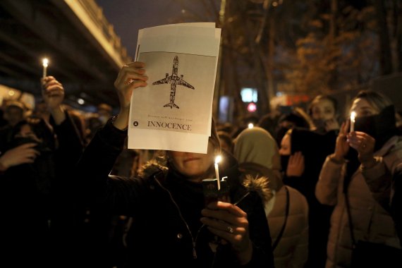 People gather for a candlelight vigil to remember the victims of the Ukraine plane crash, at the gate of Amri Kabir University that some of the victims of the crash were former students of, in Tehran, Iran, Saturday, Jan. 11, 2020. Iran on Saturday, Jan. 11, acknowledged that its armed forces 'unint