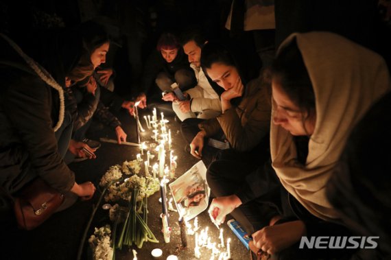 [테헤란=AP/뉴시스]이란 수도 테헤란 아미르 카비르 대학 앞에서 11일(현지시간) 시민들이 우크라이나 여객기 오인 격추로 희생된 사람들을 추모하는 촛불을 켜고 있다. 이날 추모회는 반정부 시위로 바뀌었다. 2020.01.12