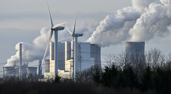 The RWE Niederaussem lignite-fired power station releases steam, behind two renewable energy producing wind turbines in Bergheim, Germany, Monday, Jan. 13, 2020. Germany plans an entirely coal phase out and to shut down all remaining coal-fired plants by 2038. (AP Photo/Martin Meissner) /뉴시스/AP /사진=