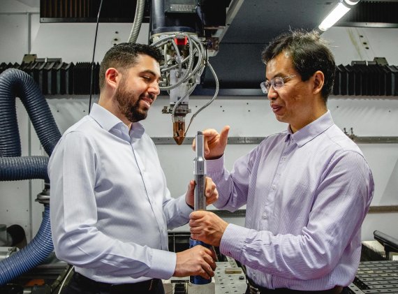호주 로열 멜버른 공과대학교의 카르멜로 토다로(왼쪽)와 마 첸이 초음파 막대의 끝에 있는 3D 프린팅된 티타늄 합금 큐브를 검사하고 있다. 로열 멜버른 공과대학교 제공