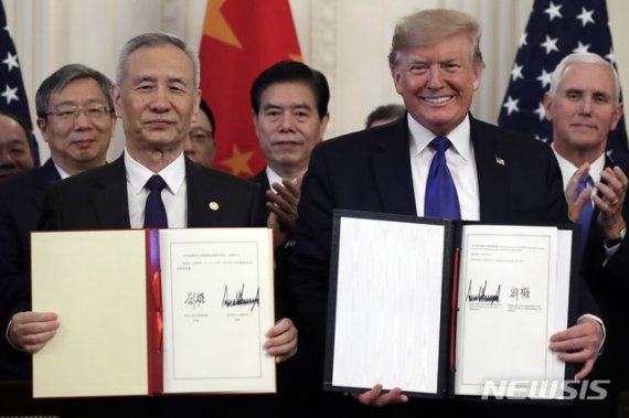 [워싱턴=AP/뉴시스]도널드 트럼프 미국 대통령과 류허(劉鶴) 중국 중앙정치국 위원 겸 부총리가 15일(현지시간) 백악관에서 미중 1단계 무역 합의안에 서명했다. 2020.1.16.