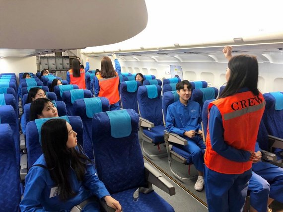 학생들이 에어부산 훈련복을 입고 모의 항공기 훈련장(MOCK-UP)에서 안전 교육을 받고 있다. /사진=에어부산