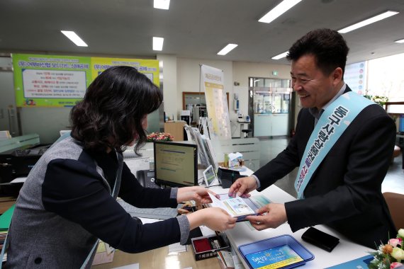 허인환 인천 동구청장(오른쪽)이 17일 지역 내 은행에서 동구사랑상품권을 시범 구매하고 있다.