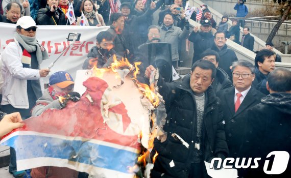 지난 2018년 1월22일 조원진 당시 대한애국당 대표와 보수단체 회원들이 서울역 앞에서 평창동계올림픽 남북 단일팀 합의에 반대하며 북한 인공기를 불태우는 모습.사진=뉴스1