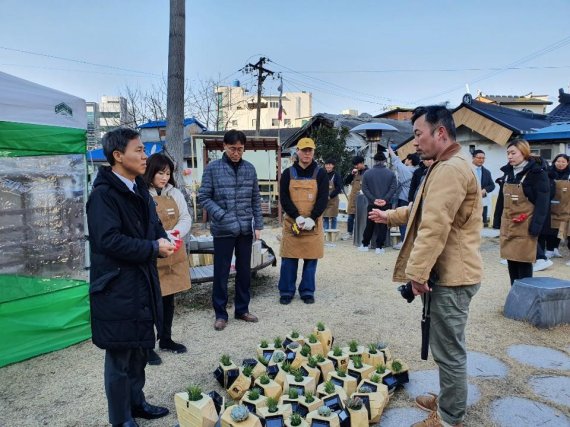 행사 참석자가 화분에 대해 설명하고 있다.