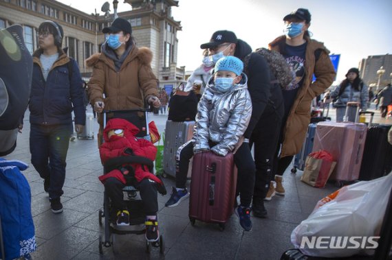 [베이징=AP/뉴시스]20일(현지시간) 중국 베이징의 베이징 철도역 앞에 여행객들이 마스크를 쓰고 이동하고 있다.<div id='ad_body2' class='ad_center'></div> 중국 정부는 우한 폐렴이 수도 베이징에서도 발생하면서 신종 코로나바이러스에 감염된 사람의 수가 급격히 늘고 있다고 발표했다. 특히 연휴를 맞아 수백만 명이 열차와 비행기를 이용하는, 중국에서 가장 인구 이동이 많은 시기와 겹쳐 대규모 확산이 우려되고 있다. 2020.01.20.