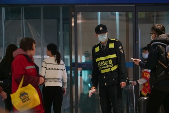 중국 후베이성 우한의 톈허 국제공항에서 21일 공항 관계자들이 온도계를 들고 여행객들을 검사하고 있다.AP뉴시스