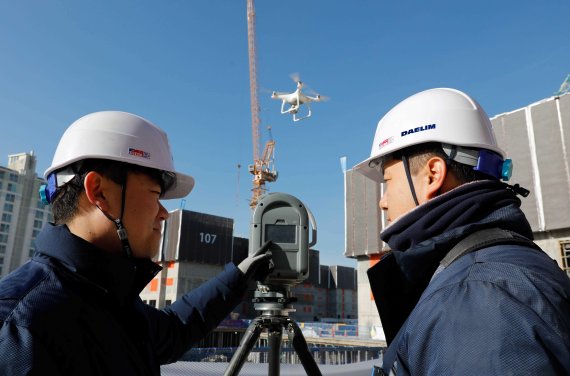 경기 김포에서 건설중인 'e편한세상 김포 로얄하임' 현장에서 대림산업 직원들이 3D 스캐너와 드론을 활용해 BIM 설계에 필요한 측량자료를 촬영하고 있다. 대림산업 제공