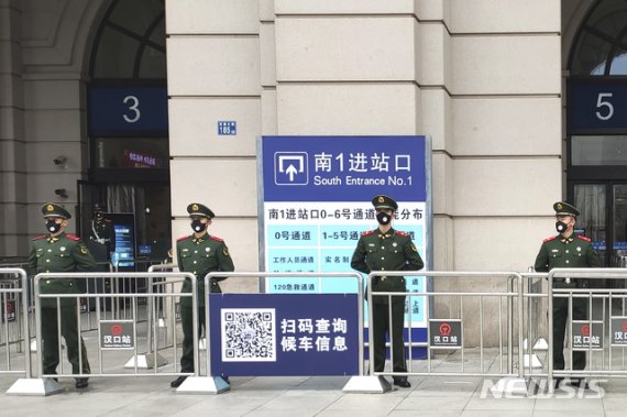 [우한=AP/뉴시스] 폐렴사태로 봉쇄령이 내려진 23일 중국 우한에서 경찰들이 폐쇄된 기차역 앞을 지키고 있다. 2020.01.23