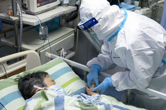 In this Friday, Jan. 24, 2020, photo released by China's Xinhua News Agency, a medical worker attends to a patient in the intensive care unit at Zhongnan Hospital of Wuhan University in Wuhan in central China's Hubei Province. China expanded its lockdown against the deadly new virus to an unpreceden