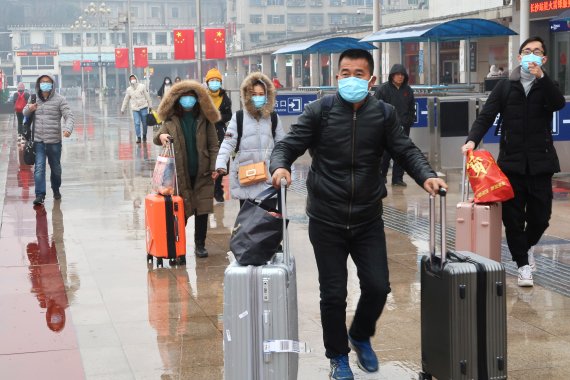 우한 폐렴이 기승을 부리는 가운데 춘절(설 명절)기간인 25일 중국 후난성 창샤역에서 귀성객들이 마스크를 쓴 채 이동하고 있다. 로이터 뉴스1