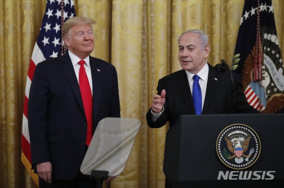 [워싱턴=AP/뉴시스]도널드 트럼프 미국 대통령이 28일(현지시간) 백악관에서 베냐민 네타냐후 이스라엘 총리와 함께 중동 평화 계획을 발표하고 있다. 2020.1.29.