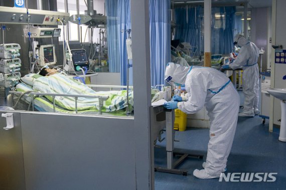 [우한=AP/뉴시스]중국 후베이성 우한시 한 병원 중환자실에서 지난 24일 의료진이 환자를 치료하고 있다. 2020.01.29.