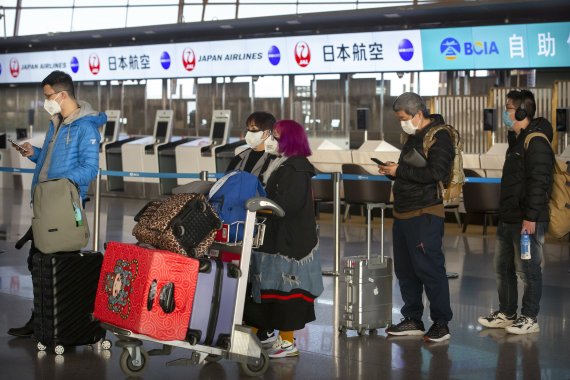 지난 1월 30일 중국 베이징 공항. 승객들이 마스크를 쓴 채 일본항공(JAL)카운터 앞에서 순서를 기다리고 있다. AP뉴시스