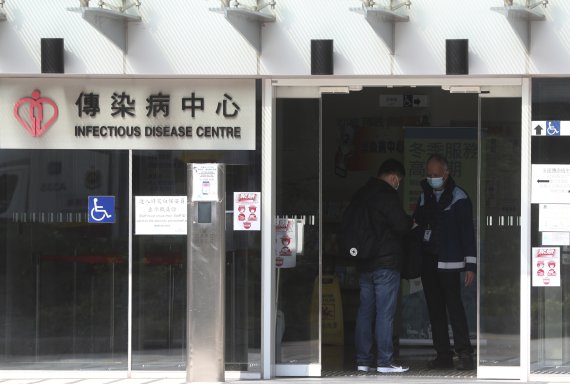 Security check a man inside the infectious disease centre at the Princess Margaret Hospital in Hong Kong, Saturday, Feb, 1, 2020. China’s death toll from a new virus continues to rise as a World Health Organization official says other governments need to prepare for“domestic outbreak control” if the