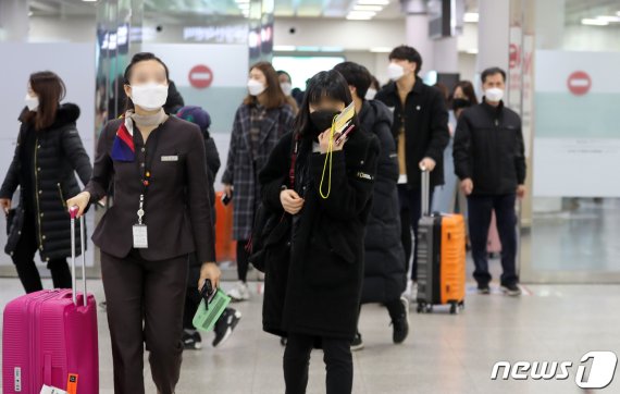 정부는 2일 오후 정세균 국무총리를 주재로 열린 신종코로나 감염증 대응 확대회의에서 제주지역 중국인 무비자 입국을 일시 중단하기로 결정했다. 이날 오후 제주국제공항 입국장으로 마스크를 쓴 여행객들이 들어서고 있다.2020.2.2/뉴스1 © News1 오현지 기자