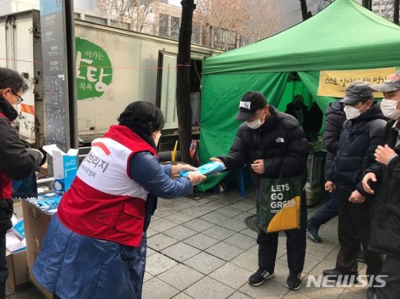 [서울=뉴시스]희망브리지 전국재해구호협회 관계자가 2일 서울 종로구 종각역 5번 출구 인근에서 노숙인에게 방역 마스크를 제공하고 있다. (사진=희망브리지 제공)photo@newsis.com