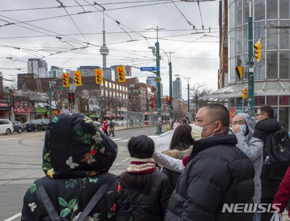 [토론토=AP/뉴시스]지난달 27일 캐나다 토론토에서 행인들이 마스크를 쓰고 거리에 나와 있다. 2020.02.03.