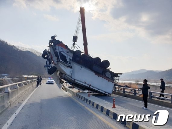 충남 공주시 검상교를 지나던 7.5톤 트럭이 가드레일을 들이받고 다리 아래로 추락하는 사고가 발생했다. 사진은 크레인으로 사고 차량을 다리 위로 올리는 모습. (독자 제공)© 뉴스1
