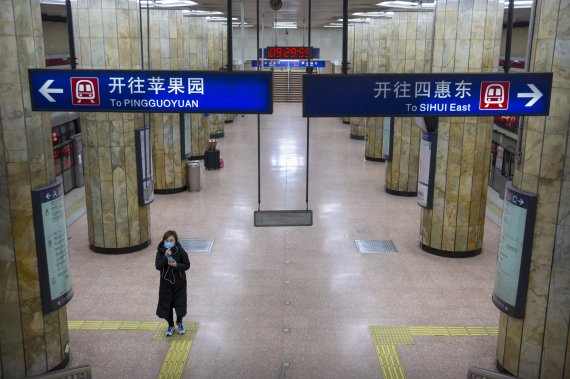 중국 베이징의 한 지하철역에서 3일 마스크를 쓴 시민이 출근시간에도 텅 빈 플랫폼을 걸어가고 있다. 중국 정부는 이날 공식적으로 춘제(설) 연휴가 끝났음에도 불구하고 신종 코로나바이러스 감염증 확산 방지를 위해 필수업종을 제외한 일반 기업에는 9일까지 재택근무나 휴무를 권했다. AP 뉴시스