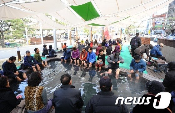 해운대구와 동래구가 신종 코로나 바이러스 감염증 예방차원에서 야외 온천족욕장 개장을 무기한 연장했다. 사진은 겨울철 해운대 온천족욕장에서 족욕을 즐기고 있는 시민들 모습. /© News1 DB