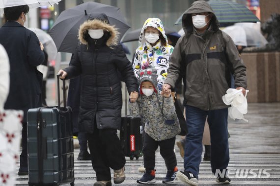 [도쿄=AP/뉴시스]마스크를 쓴 중국 관광객들이 지난달 28일 일본 도쿄 거리를 걷고 있다. 2020.01.28