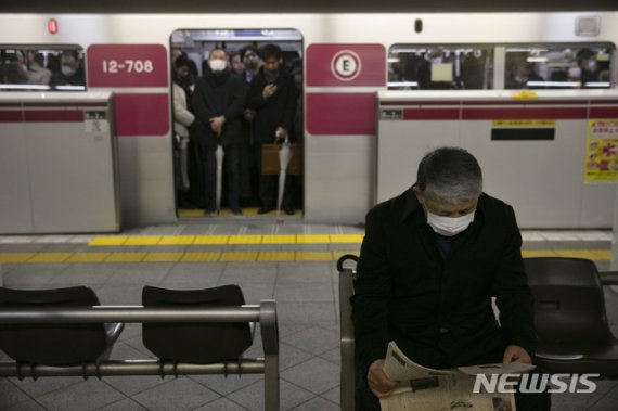 [도쿄=AP/뉴시스]일본 도쿄 지하철 내에서 지난달 28일 오전 한 시민이 마스크를 쓰고 열차가 도착하기를 기다리며 신문을 읽고 있다. 우한 폐렴으로 불리는 신종 코로나바이러스 감염증이 전세계로 확산하면서 마스크 착용 등 예방법에 대한 시민들의 관심이 높아지고 있다. 2020.01.28.
