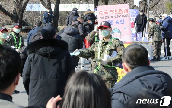 3일 오후 충남 논산 육군훈련소 입영심사대 앞에서 군인장병이 입영장병들에게 마스크를 나누주고 있다. 신종 코로나바이러스 확산 방지 차원에서 육군훈련소는 예정된 입영행사를 취소했다. 2020.2.3/뉴스1 © News1 김기태 기자