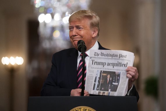President Donald Trump holds up a newspaper with a headline that reads 'Trump acquitted' as he speaks in the East Room of the White House, Thursday, Feb. 6, 2020, in Washington. (AP Photo/Evan Vucci) /뉴시스/AP /사진=