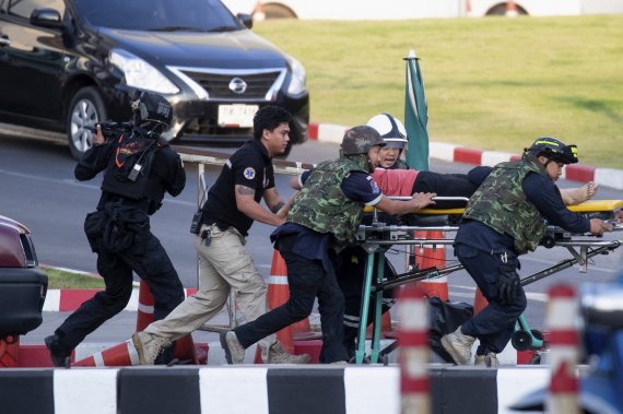 태국 북동부의 나콘랏차시마의 터미널21 코랏 몰에서 9일 구급요원들이 군인들의 엄호를 받으며 환자를 이송하고 있다.AP뉴시스