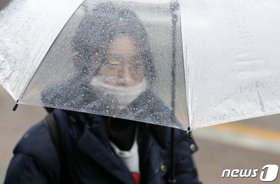 겨울비가 내린 12일 오전 대전 시청 앞에서 마스크를 착용한 시민이 우산을 쓰고 이동하고 있다. 2020.2.12/뉴스1 © News1 김기태 기자