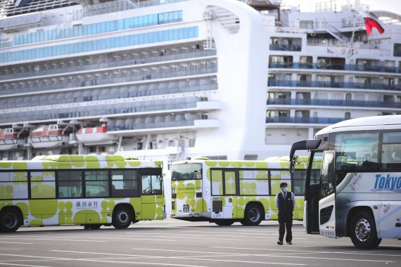 일본 요코하마 항구에서 19일 '다이아몬드 프린세스'호 승객들을 옮기기 위해 동원된 버스들이 배 주변에 모여들고 있다. 이날 일본 정부는 신종 코로나 바이러스 감염증(코로나19) 확산때문에 지난 3일부터 격리된 유람선에서 짐복기 이후에도 음성 판정을 받은 승객들에게 하선 허가를 내렸다. 같은날 약 3100명의 탑승자 가운데 500여명이 땅을 밟았다. 일본 정부는 오는 21일까지 하선 절차를 마칠 계획이다. AP 뉴시스