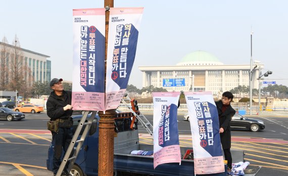 20일 국회 앞 의사당대로에서 서울시 선거관리위원회 관계자들이 오는 4월 15일 실시되는 제21대 국회의원선거 투표 독려를 위한 현수기를 걸고 있다. 사진=김범석 기자